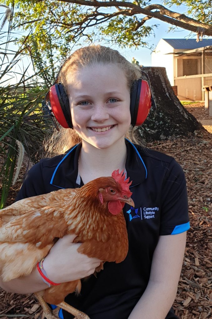 Summer with a pair of headphones she purchased for community use.