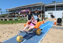 CQU Occupational Therapy students assisting in beach activities.