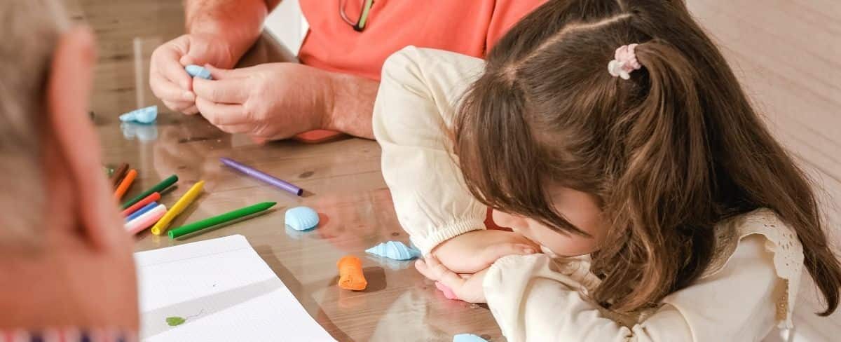Young and old participants create seashell art together.