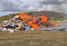 Battery sparks fire in a truck and the rubbish is seen burning in an open paddock.