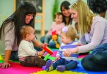 Children’s Toy and Clothing Swap A group of mothers and their toddlers are sitting together at preschool and are playing with toys.