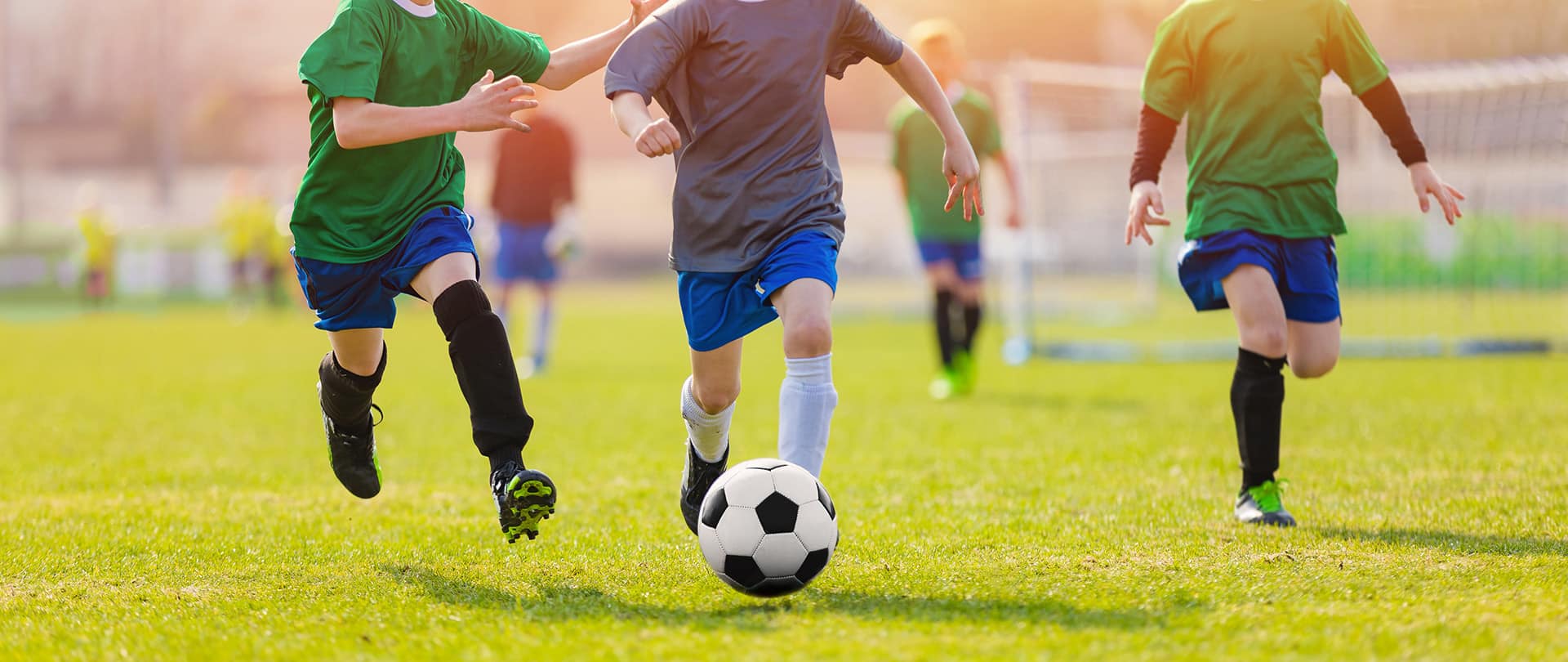 kids running on a field after a soccer ball