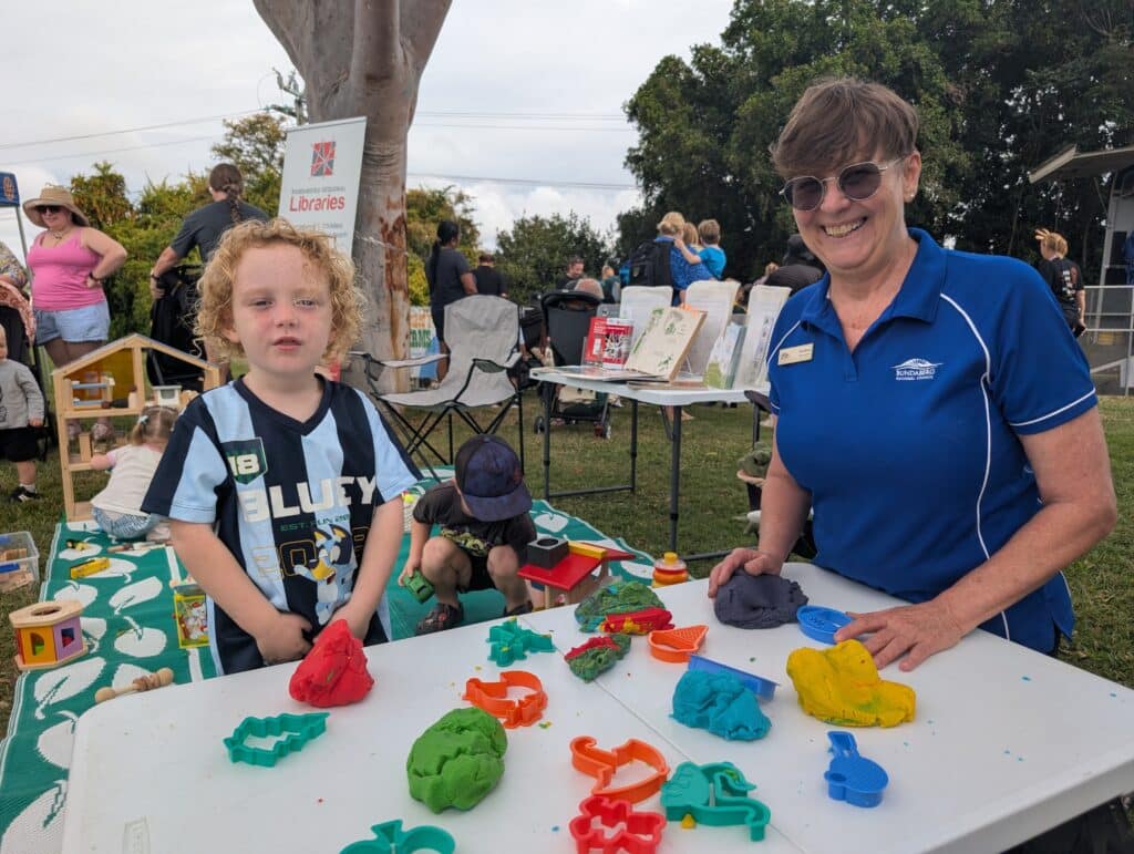 Kobe Raynor enjoys the Childers Library station with Kim Greene.
