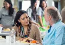 Bundaberg community backs residents Doing It Tough Volunteer having lunch with a senior man